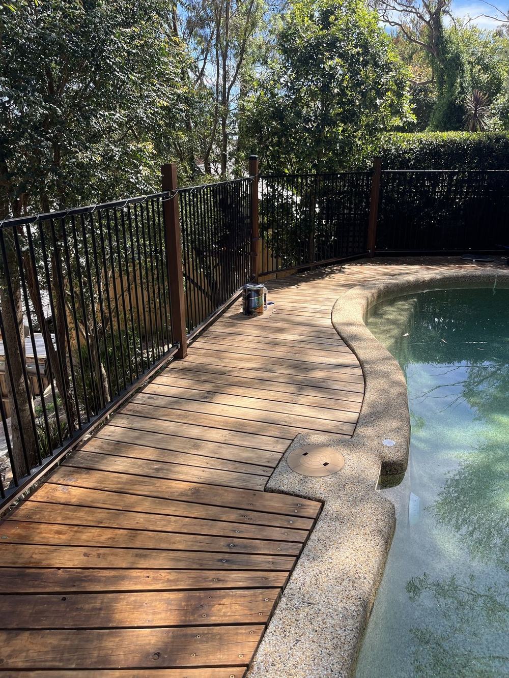 Faded timber pool deck along the pool fence before restaining