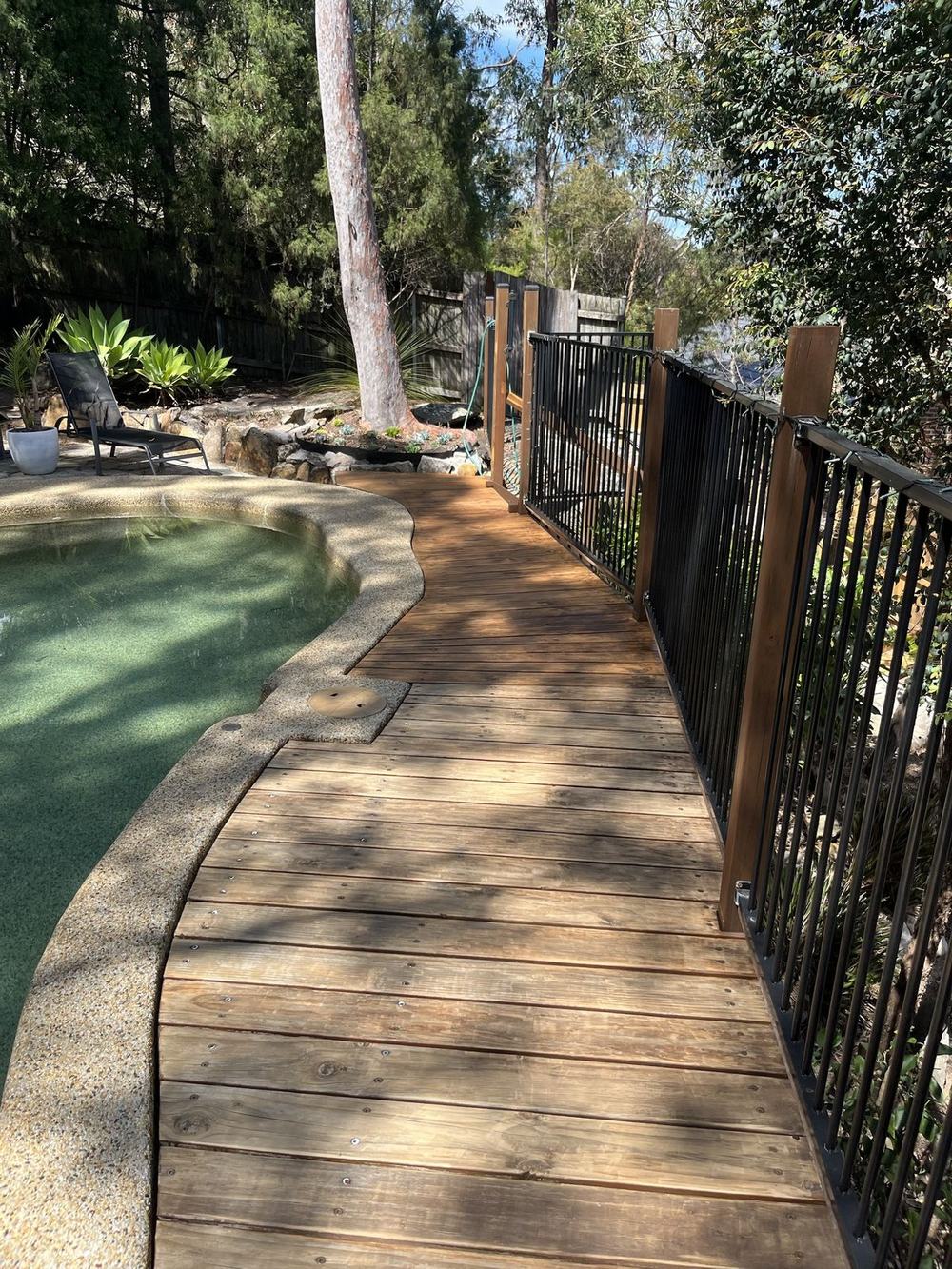 Weathered grey timber pool deck before sanding and staining