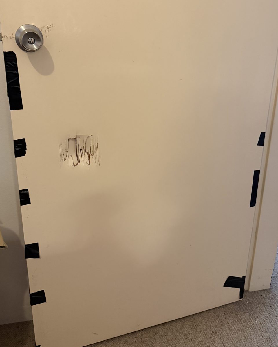 A split, gouged and taped-up bedroom door before replacement
